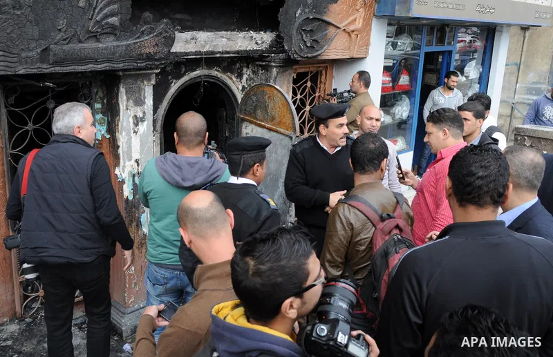 Onlookers gather at the scene of a petrol bomb attack on a Cairo disco in the Agouza neighbourhood of the Egyptian capital's Giza district on December 4, 2015. At least 16 people were killed and two wounded in the early...
