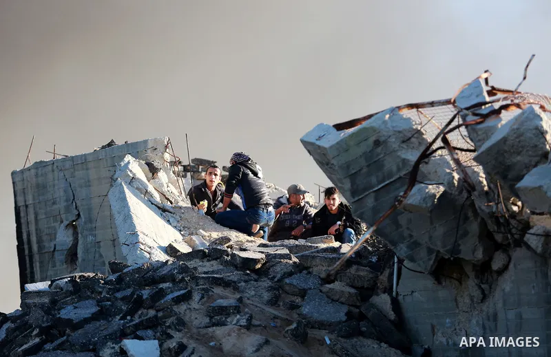 Palestinian protesters take cover during clashes with Israeli security forces along the border with Israel in the eastern suburbs of Gaza City on December 4, 2015. Israeli troops shot and injured two Palestinians in the...