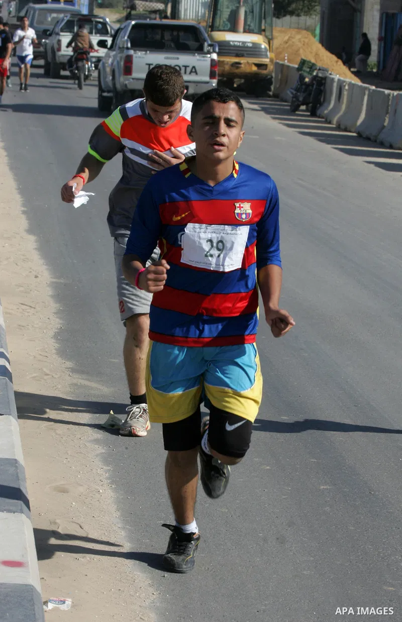 Palestinian youths take part in a marathon organized by Hamas movement to mark anniversary of the founding Hamas and demanding the Egyptian authorities for the opening of the Rafah crossing in Rafah in the southern Gaza...