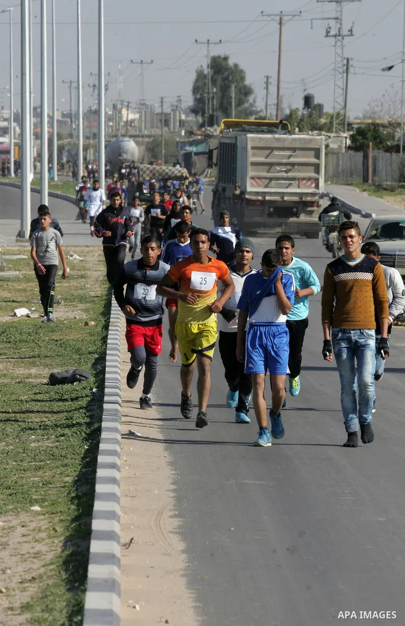 Palestinian youths take part in a marathon organized by Hamas movement to mark anniversary of the founding Hamas and demanding the Egyptian authorities for the opening of the Rafah crossing in Rafah in the southern Gaza...