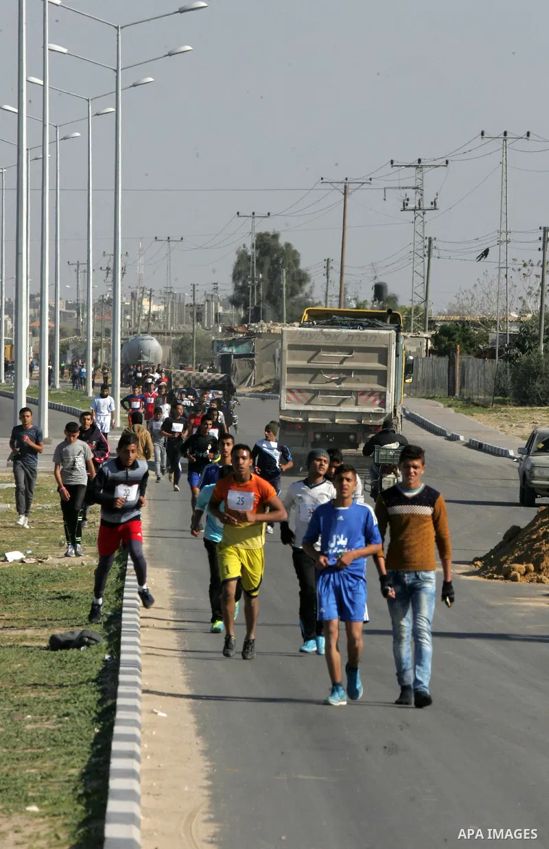 Palestinian youths take part in a marathon organized by Hamas movement to mark anniversary of the founding Hamas and demanding the Egyptian authorities for the opening of the Rafah crossing in Rafah in the southern Gaza...
