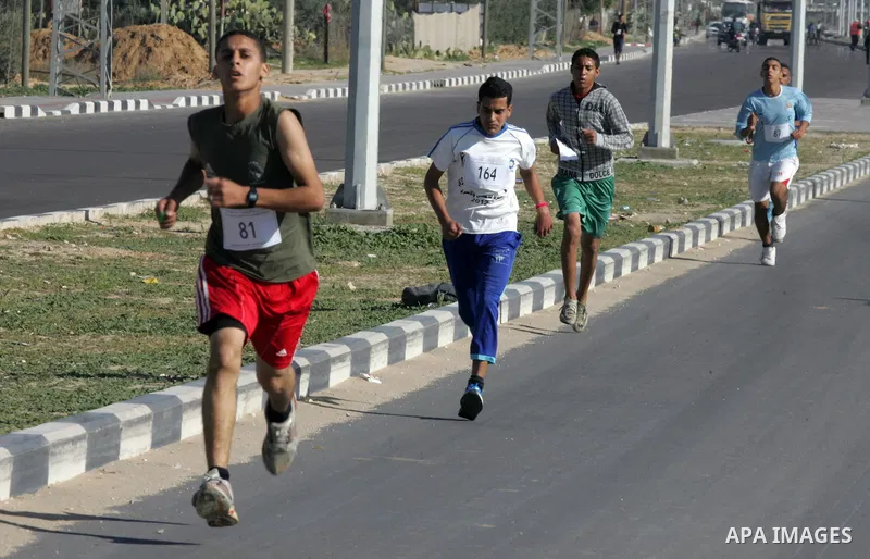 Palestinian youths take part in a marathon organized by Hamas movement to mark anniversary of the founding Hamas and demanding the Egyptian authorities for the opening of the Rafah crossing in Rafah in the southern Gaza...
