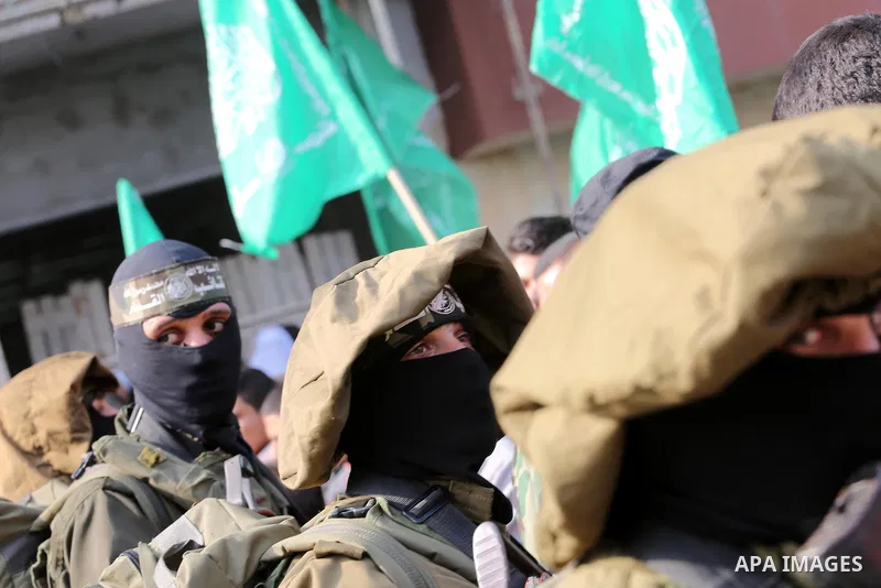 Palestinian militants of the Ezzedine al-Qassam Brigades, the armed wing of the Hamas movement, stand guard during a parade to mark the 28th anniversary of the Islamist movements creation on December 11, 2015, in the Jab...