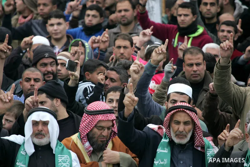Palestinians attend a military parade by members of the Ezzedine al-Qassam Brigades, the armed wing of the Hamas movement, on December 11, 2015, to mark the ruling Islamist movement's 28th birthday in Khan Yunis, in the...