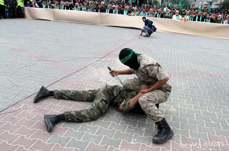 Palestinian militants of the Ezzedine al-Qassam Brigades, the armed wing of the Hamas movement, show their skills during a parade marking the ruling Islamist movement's 28th birthday on December 11, 2015, in Khan Yunis,...