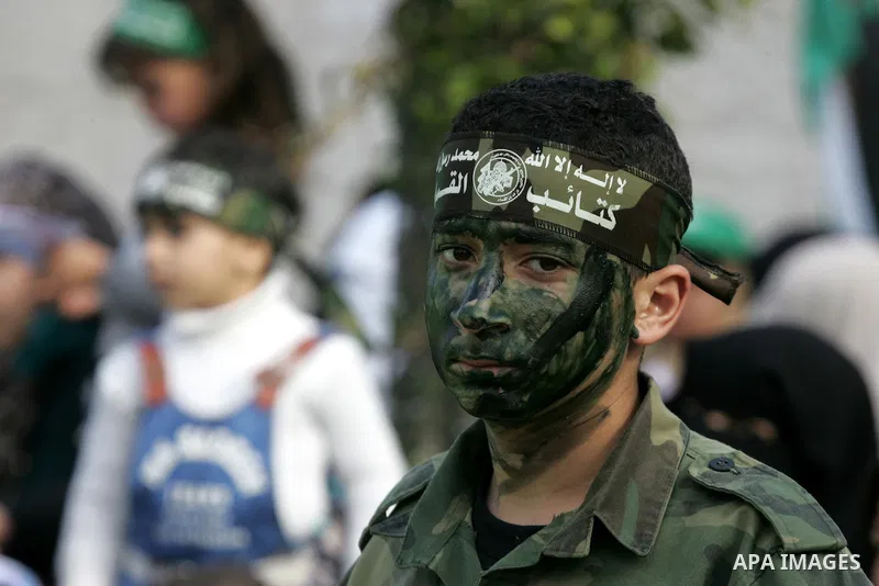 Palestinians attend a military parade by members of the Ezzedine al-Qassam Brigades, the armed wing of the Hamas movement, on December 11, 2015, to mark the ruling Islamist movement's 28th birthday in Khan Yunis, in the...