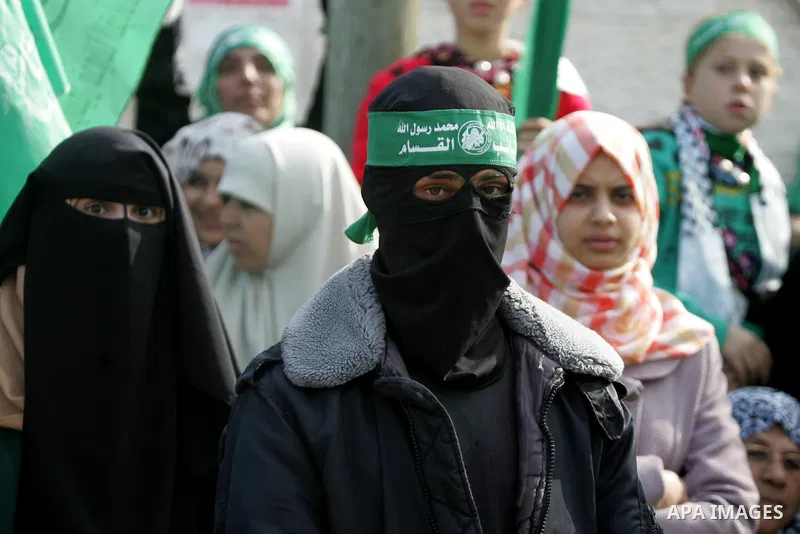 Palestinians attend a military parade by members of the Ezzedine al-Qassam Brigades, the armed wing of the Hamas movement, on December 11, 2015, to mark the ruling Islamist movement's 28th birthday in Khan Yunis, in the...