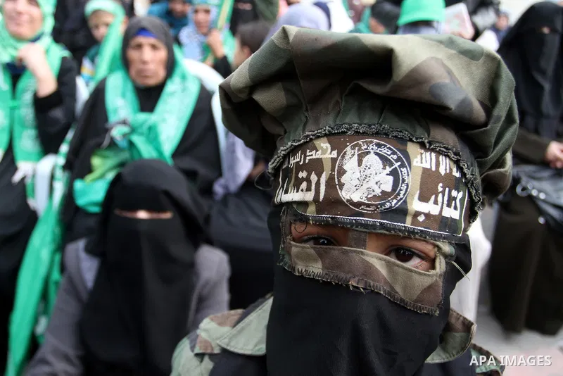 Palestinians attend a military parade by members of the Ezzedine al-Qassam Brigades, the armed wing of the Hamas movement, on December 11, 2015, to mark the ruling Islamist movement's 28th birthday in Khan Yunis, in the...