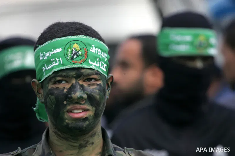 Palestinians attend a military parade by members of the Ezzedine al-Qassam Brigades, the armed wing of the Hamas movement, on December 11, 2015, to mark the ruling Islamist movement's 28th birthday in Khan Yunis, in the...