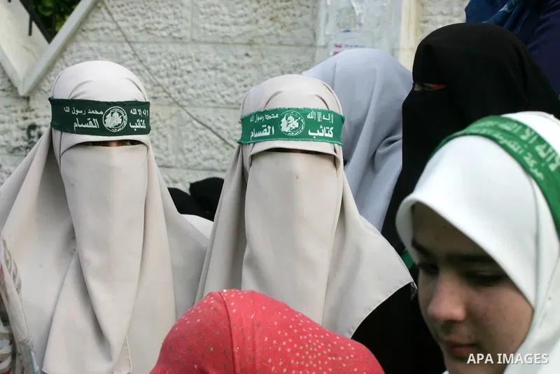 Palestinians attend a military parade by members of the Ezzedine al-Qassam Brigades, the armed wing of the Hamas movement, on December 11, 2015, to mark the ruling Islamist movement's 28th birthday in Khan Yunis, in the...