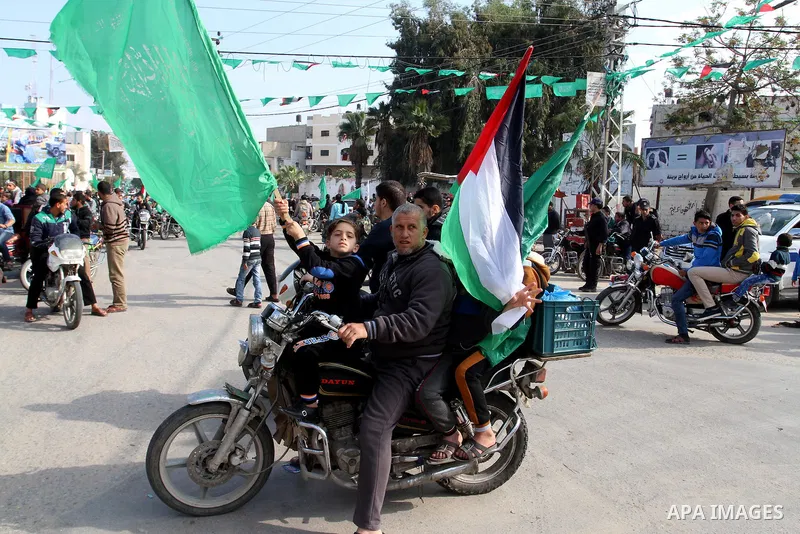 Palestinians attend a military parade by members of the Ezzedine al-Qassam Brigades, the armed wing of the Hamas movement, on December 11, 2015, to mark the ruling Islamist movement's 28th birthday in Khan Yunis, in the...
