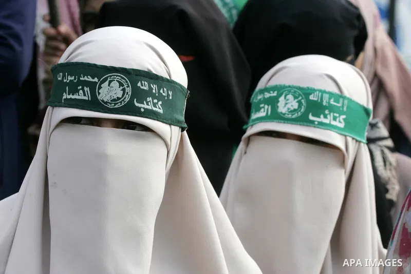 Palestinians attend a military parade by members of the Ezzedine al-Qassam Brigades, the armed wing of the Hamas movement, on December 11, 2015, to mark the ruling Islamist movement's 28th birthday in Khan Yunis, in the...