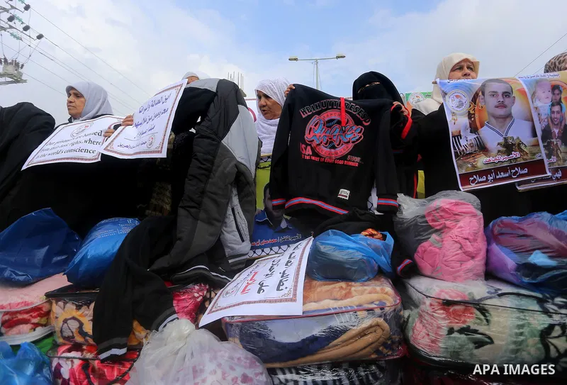 Relatives of Palestinian prisoners take part in a protest demanding to the entery of the winter clothing for their prisoners in Israeli jails, outside Eriz crossing in the northern Gaza Strip, on Dec. 17, 2015. Photo by...