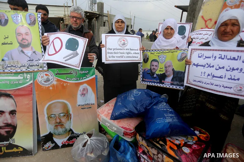 Relatives of Palestinian prisoners take part in a protest demanding to the entery of the winter clothing for their prisoners in Israeli jails, outside Eriz crossing in the northern Gaza Strip, on Dec. 17, 2015. Photo by...