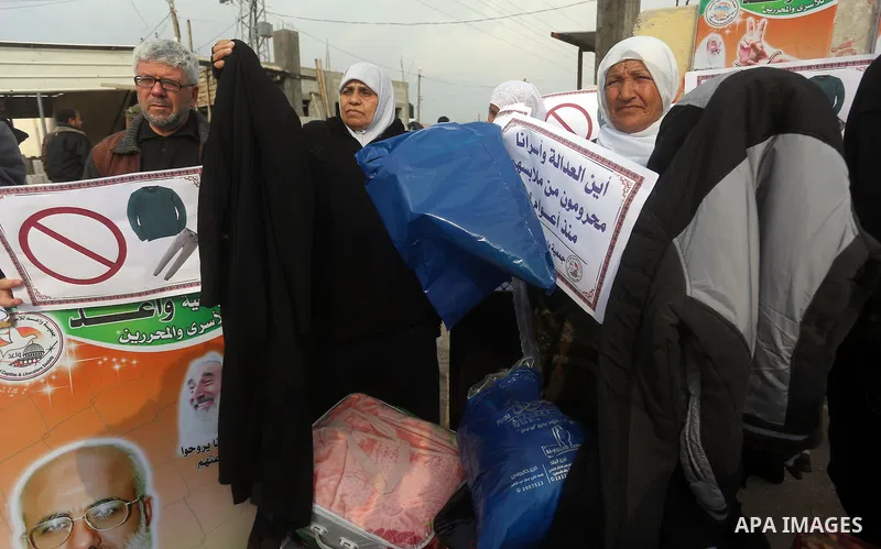 Relatives of Palestinian prisoners take part in a protest demanding to the entery of the winter clothing for their prisoners in Israeli jails, outside Eriz crossing in the northern Gaza Strip, on Dec. 17, 2015. Photo by...