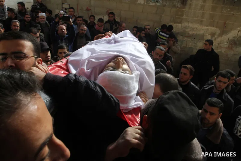 Mourners carry the body of Palestinian Mahmoud Al-Aga, 20, whom medics said was killed by Israeli troops during clashes with Palestinian protesters on Friday, during his funeral in Khan Younis in the southern of Gaza Str...