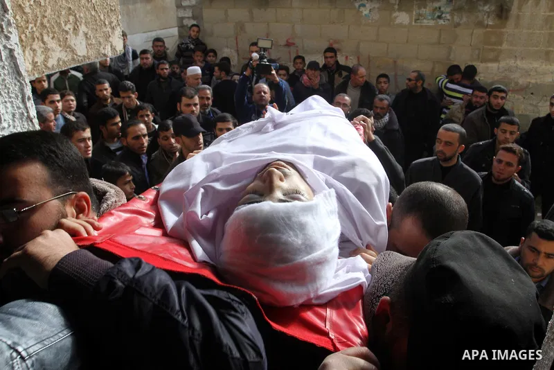 Mourners carry the body of Palestinian Mahmoud Al-Aga, 20, whom medics said was killed by Israeli troops during clashes with Palestinian protesters on Friday, during his funeral in Khan Younis in the southern of Gaza Str...