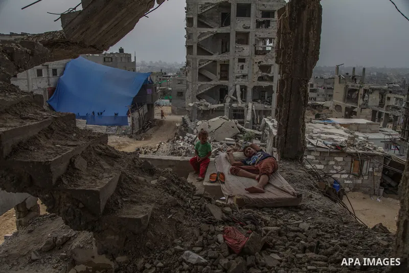 Palestinian children from the Al Atawna family sit amid the rubble of their destroyed house which was damaged during the Israeli-Hamas conflict of 2014, in the Al-Shejaeiya neighbourhood in the east of Gaza City, Gaza St...