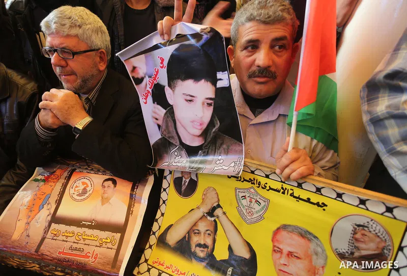 Palestinians take part in a protest demanding release the prisoners in Israeli jails, in front of Red cross office, in Gaza city, on December 28, 2015. Photo by Mohammed Asad