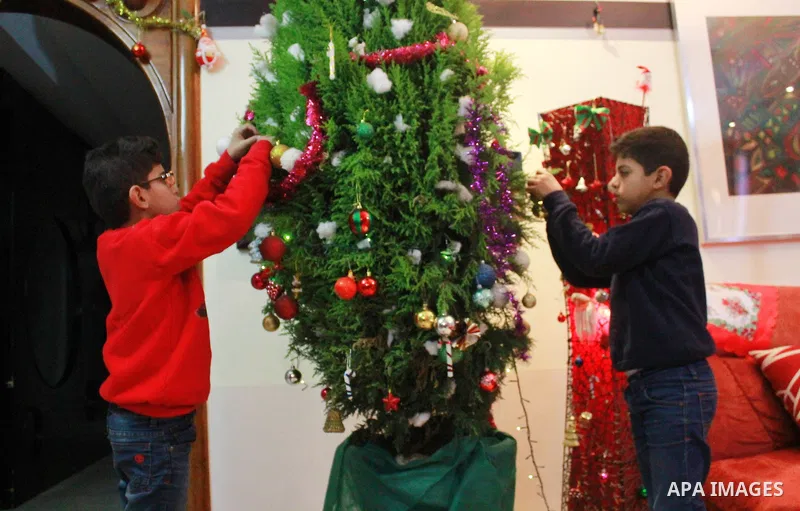 An Egyptian Christian family decorate a Christmas tree at their house in Cairo, Egypt on Dec. 30, 2015. Photo by Amr Sayed