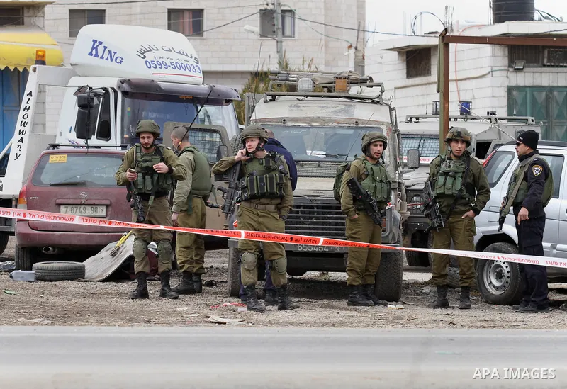 Israeli security forces gather at the site of a car ramming attack in the village of Hawara near the West Bank city of Nablus, on December 31, 2015. A Palestinian drove his car into Israeli forces before being shot dead,...