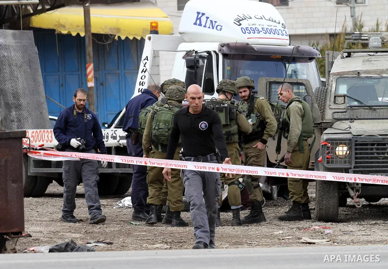 Israeli security forces gather at the site of a car ramming attack in the village of Hawara near the West Bank city of Nablus, on December 31, 2015. A Palestinian drove his car into Israeli forces before being shot dead,...