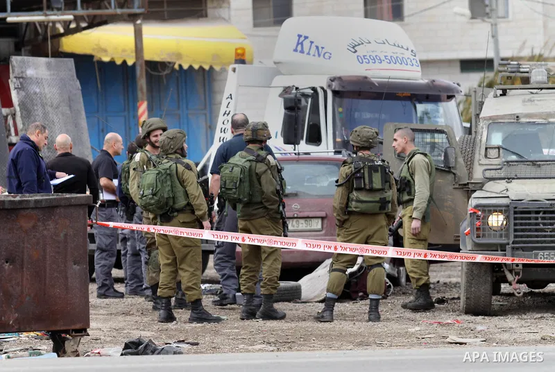 Israeli security forces gather at the site of a car ramming attack in the village of Hawara near the West Bank city of Nablus, on December 31, 2015. A Palestinian drove his car into Israeli forces before being shot dead,...