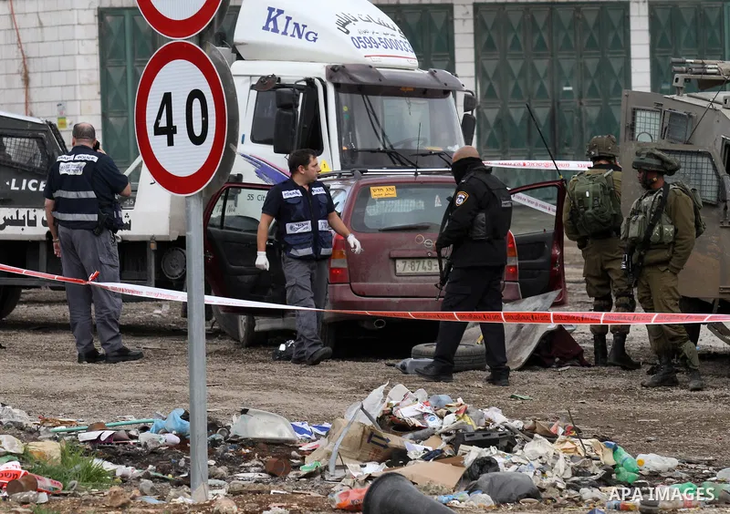 Israeli security forces gather at the site of a car ramming attack in the village of Hawara near the West Bank city of Nablus, on December 31, 2015. A Palestinian drove his car into Israeli forces before being shot dead,...