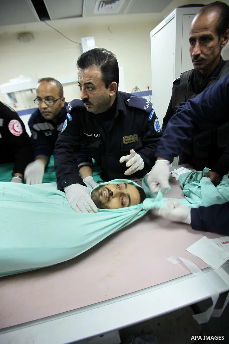 Members of the Palestinian police and medical staff inspect the body of a man who drove his car into Israeli forces in the village of Hawara near the West Bank city of Nablus before being shot dead earlier in the day on...