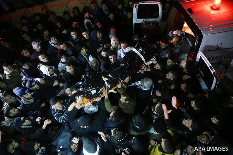 Palestinian men carry a body of a Palestinian alleged attacker upon its release by the Israeli security forces in the West Bank city of Ramallah, on December 31, 2015. Israeli authorities turned over a number of bodies t...