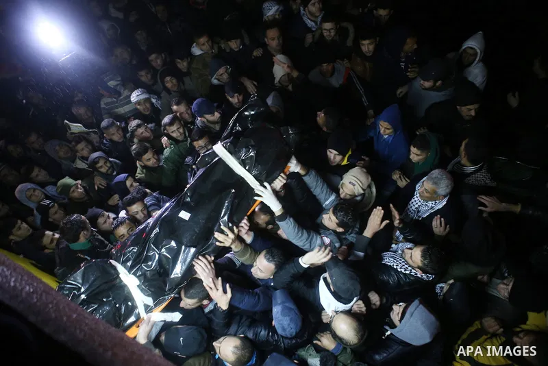 Palestinian men carry a body of a Palestinian alleged attacker upon its release by the Israeli security forces in the West Bank city of Ramallah, on December 31, 2015. Israeli authorities turned over a number of bodies t...