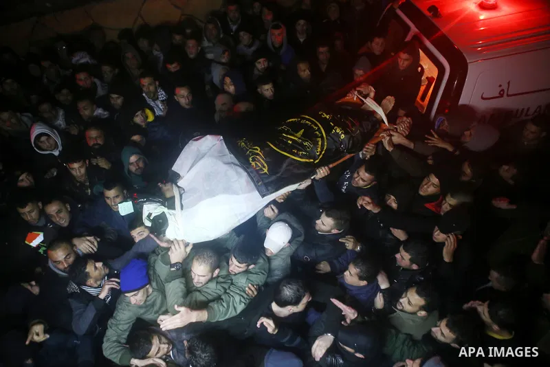 Palestinian men carry a body of a Palestinian alleged attacker upon its release by the Israeli security forces in the West Bank city of Ramallah, on December 31, 2015. Israeli authorities turned over a number of bodies t...