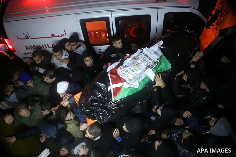 Palestinian men carry a body of a Palestinian alleged attacker upon its release by the Israeli security forces in the West Bank city of Ramallah, on December 31, 2015. Israeli authorities turned over a number of bodies t...