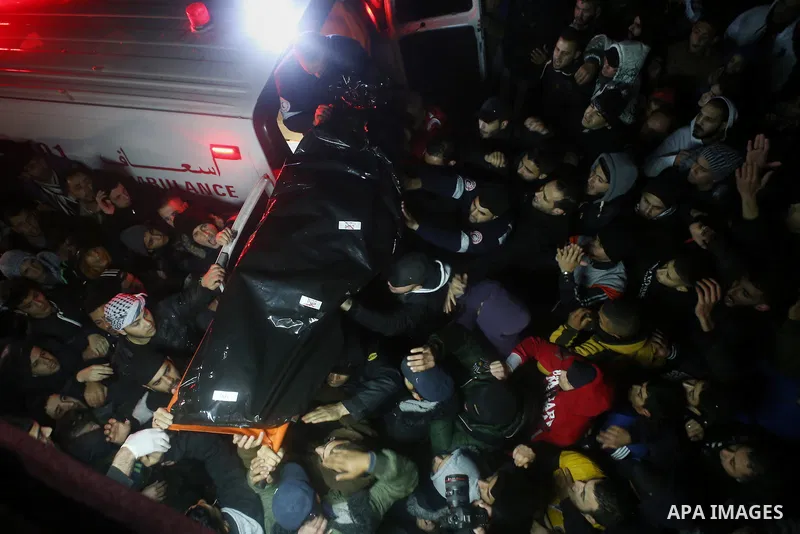 Palestinian men carry a body of a Palestinian alleged attacker upon its release by the Israeli security forces in the West Bank city of Ramallah, on December 31, 2015. Israeli authorities turned over a number of bodies t...