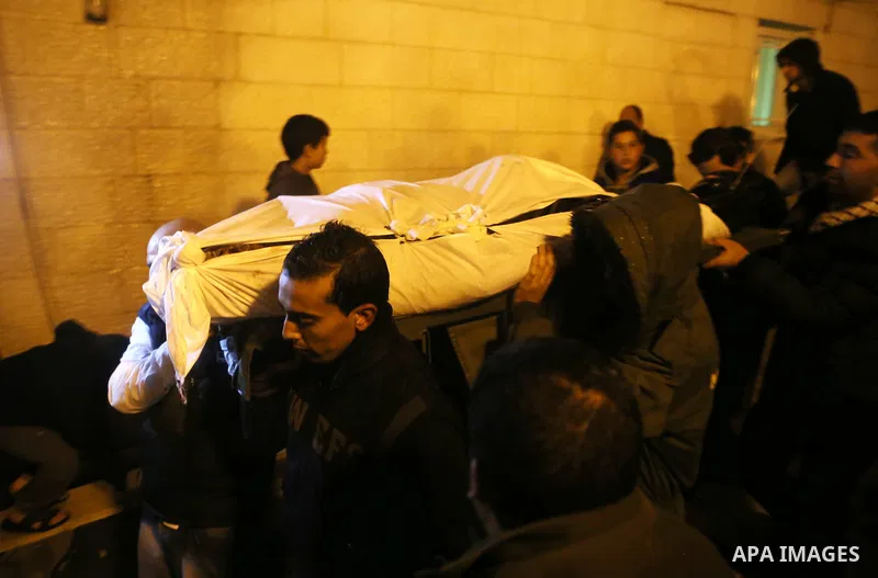 Palestinian men carry a body of a Palestinian alleged attacker upon its release by the Israeli security forces in the West Bank city of Ramallah, on December 31, 2015. Israeli authorities turned over a number of bodies t...