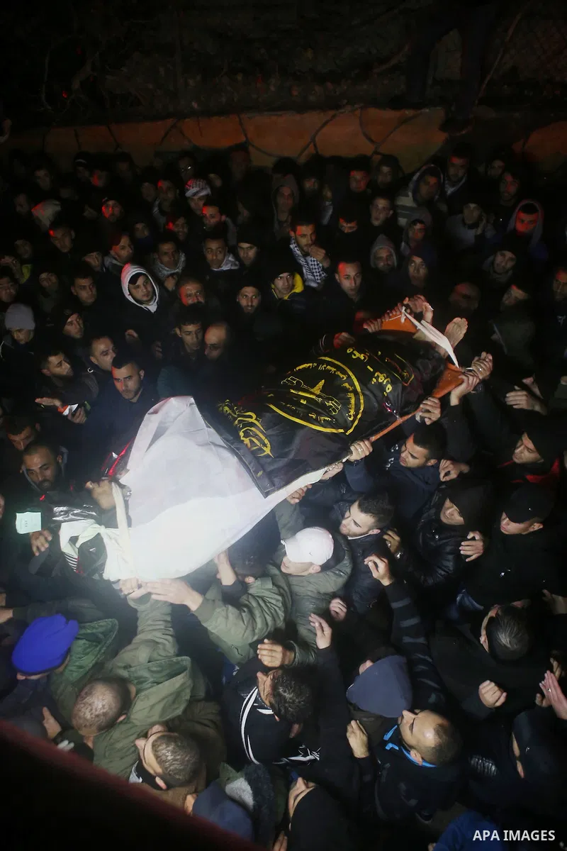 Palestinian men carry a body of a Palestinian alleged attacker upon its release by the Israeli security forces in the West Bank city of Ramallah, on December 31, 2015. Israeli authorities turned over a number of bodies t...