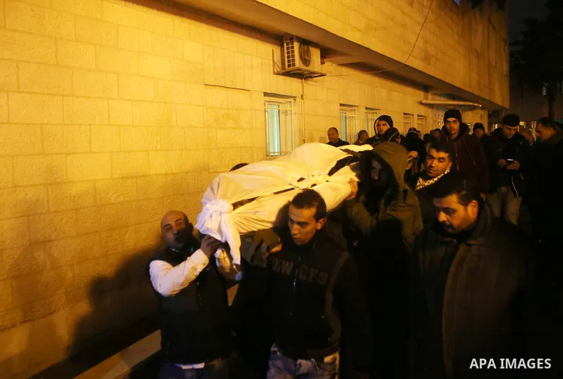 Palestinian men carry a body of a Palestinian alleged attacker upon its release by the Israeli security forces in the West Bank city of Ramallah, on December 31, 2015. Israeli authorities turned over a number of bodies t...
