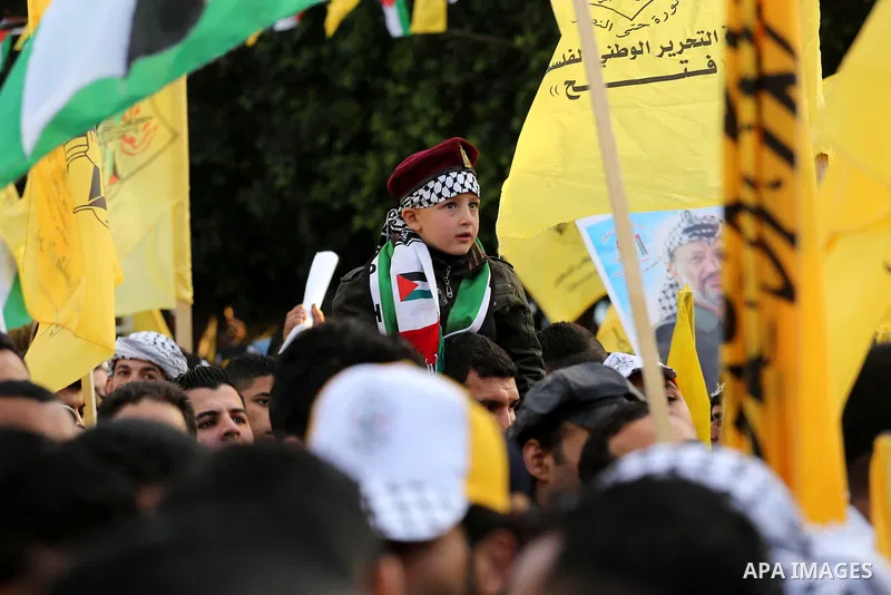 Palestinian Fatah supporters celebrate during a rally as they mark the 51st anniversary of the founding of the Fatah movement, in Gaza City December 31, 2015. Photo by Mohammed Asad