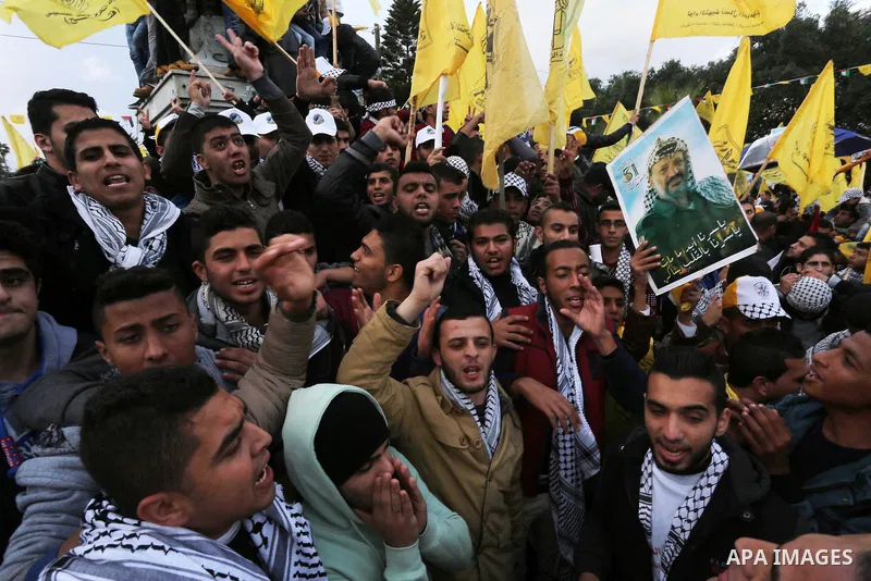 Palestinian Fatah supporters celebrate during a rally as they mark the 51st anniversary of the founding of the Fatah movement, in Gaza City December 31, 2015. Photo by Mohammed Asad