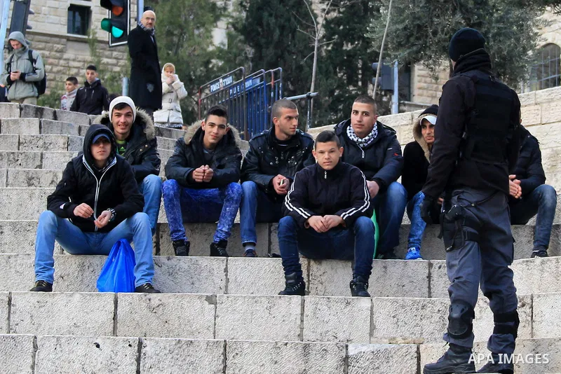 Israeli policemen check the IDs of Palestinian youths in front of Damascus gate, in Jerusalem's old city on Dec. 31, 2015. The Commission of Prisoners’ Affairs (CPA) said that at least 6,830 Palestinians were detained by...