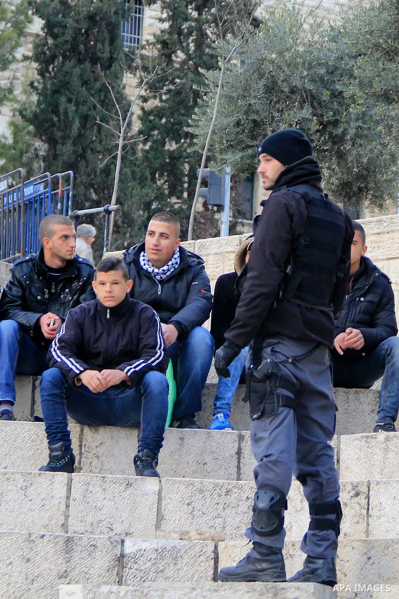 Israeli policemen check the IDs of Palestinian youths in front of Damascus gate, in Jerusalem's old city on Dec. 31, 2015. The Commission of Prisoners’ Affairs (CPA) said that at least 6,830 Palestinians were detained by...