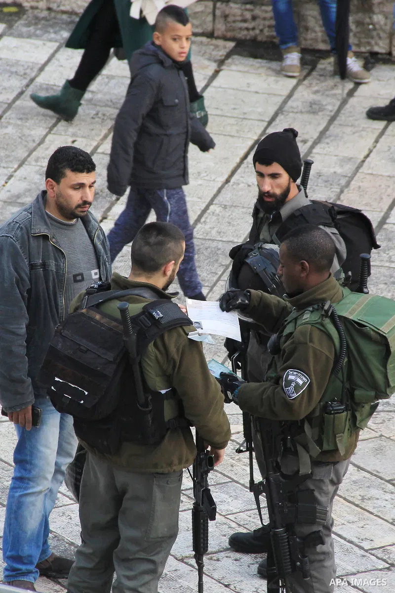 Israeli policemen check the IDs of Palestinian youths in front of Damascus gate, in Jerusalem's old city on Dec. 31, 2015. The Commission of Prisoners’ Affairs (CPA) said that at least 6,830 Palestinians were detained by...