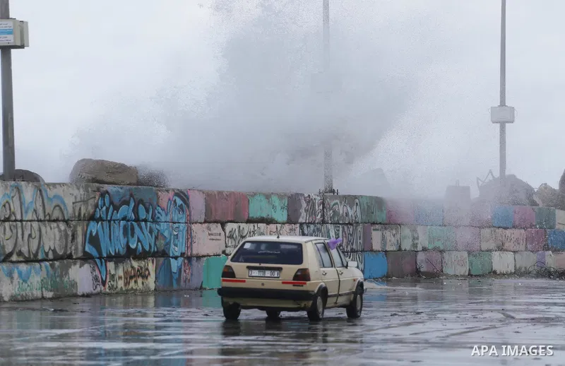 A Palestinian drive his car in a flooded street at the beach of Gaza city on the first day of the new year on Jan. 01, 2016. Photo by Mohammed Asad