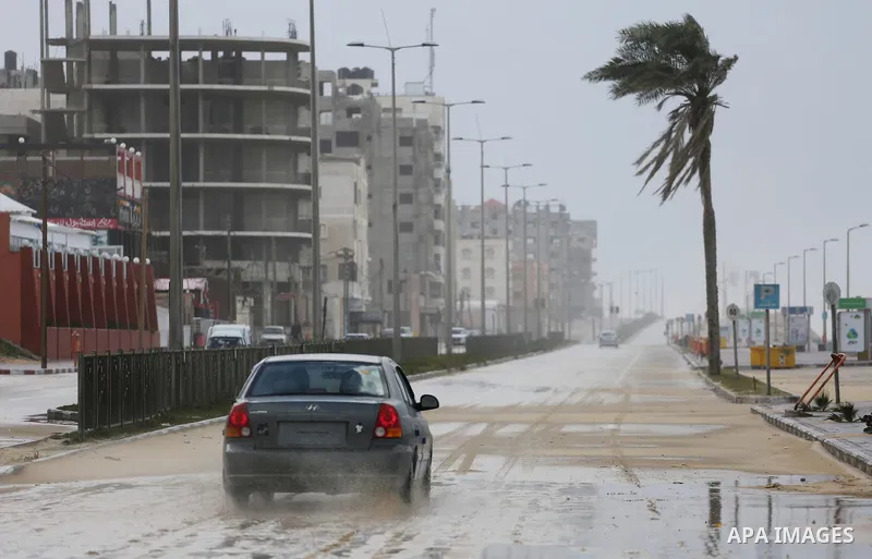 A Palestinian drive his car in a flooded street at the beach of Gaza city on the first day of the new year on Jan. 01, 2016. Photo by Mohammed Asad