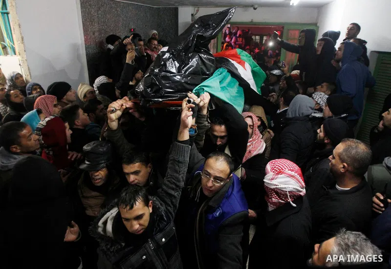 Palestinian men carry the body of a Palestinian alleged attacker upon its release by the Israeli security forces in the West Bank city of Hebron, on Jan. 01, 2016. Palestinians received on Friday 17 bodies of alleged ass...