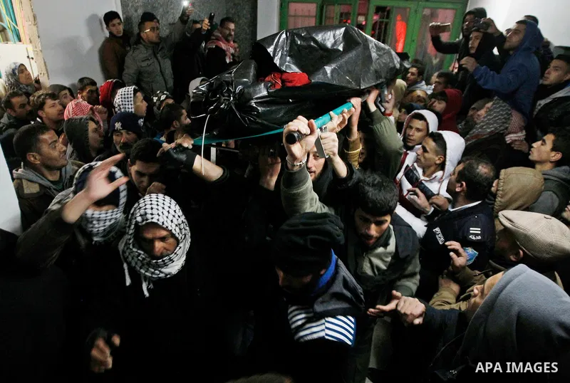 Palestinian men carry the body of a Palestinian alleged attacker upon its release by the Israeli security forces in the West Bank city of Hebron, on Jan. 01, 2016. Palestinians received on Friday 17 bodies of alleged ass...