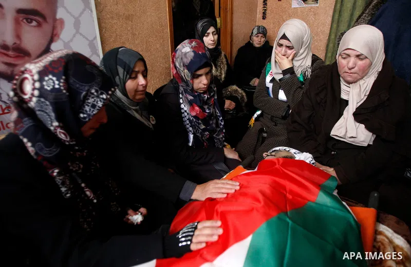 Palestinians carry the body of Fadel Qawasma during his funeral in the West Bank city of Hebron on January 2, 2016. Photo by Wisam Hashlamoun