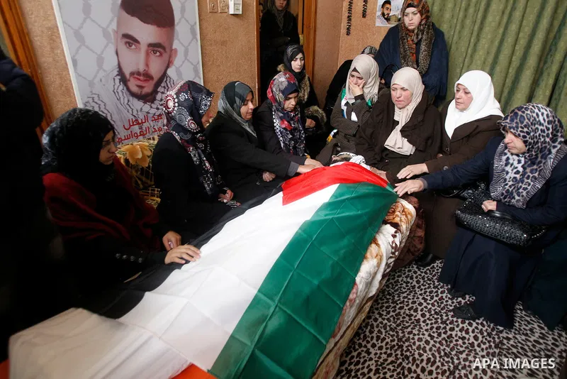 Palestinians carry the body of Fadel Qawasma during his funeral in the West Bank city of Hebron on January 2, 2016. Photo by Wisam Hashlamoun