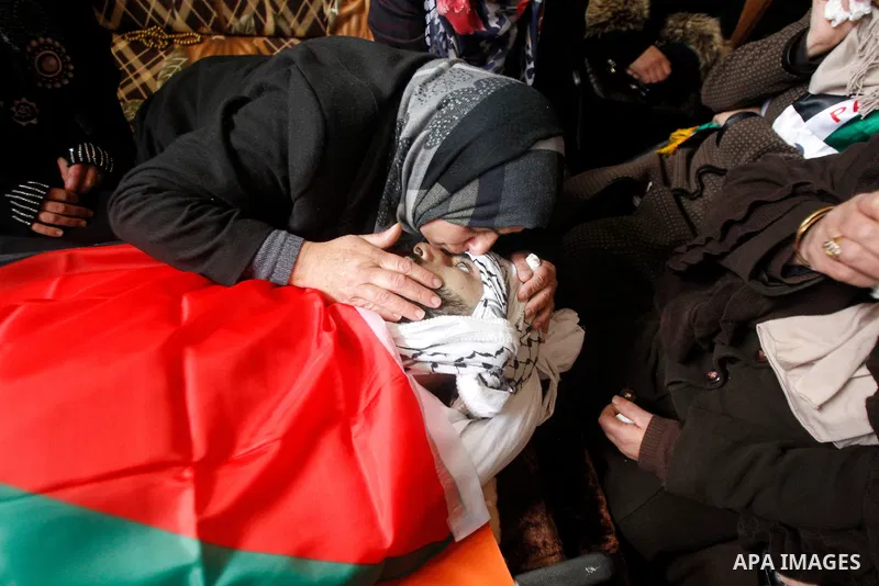 The mother of Palestinian Fadel Qawasma, mourns as she looks at his body during his funeral in the West Bank city of Hebron, on January 2, 2016. Photo by Wisam Hashlamoun