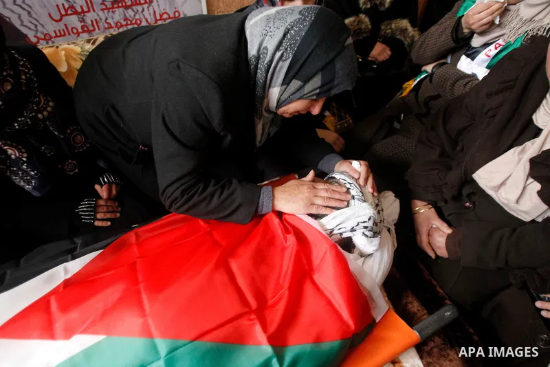 The mother of Palestinian Fadel Qawasma, mourns as she looks at his body during his funeral in the West Bank city of Hebron, on January 2, 2016. Photo by Wisam Hashlamoun